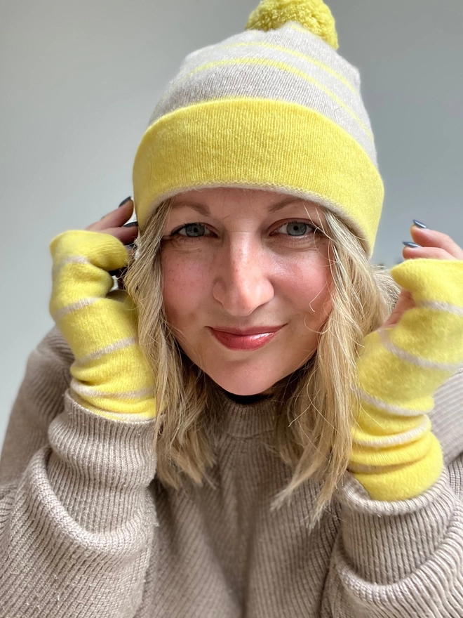 Yellow knitted wristwarmers worn with matching beanie hat