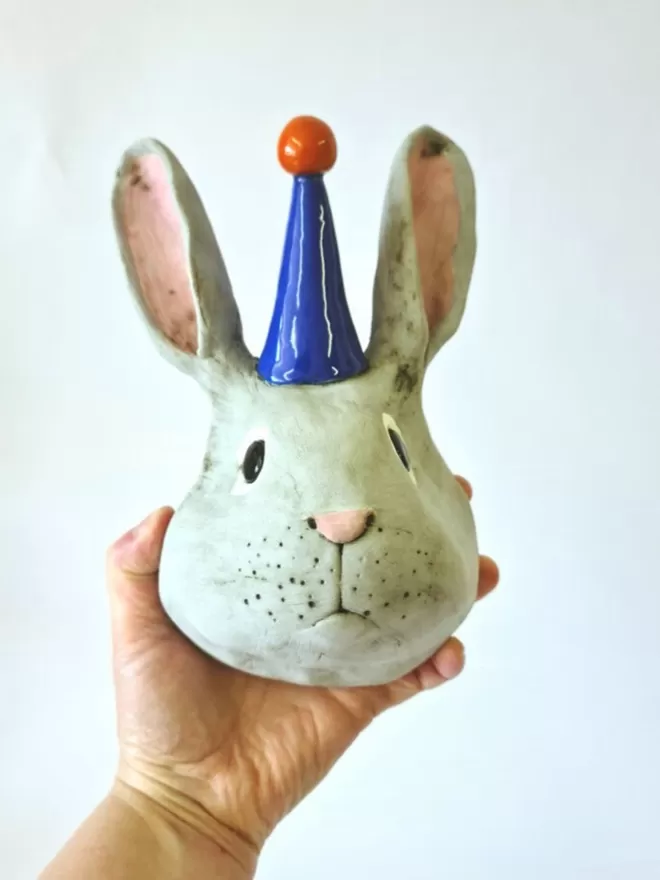 Bobby the rabbit trophy style head seen held by a hand.