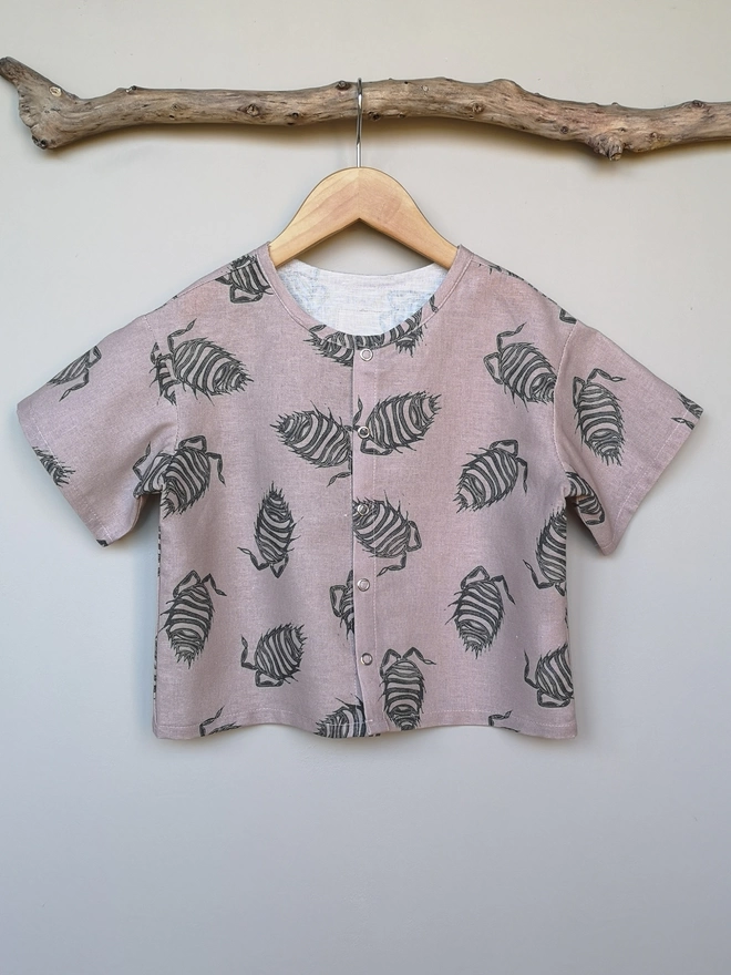 A lightweight soft pink popper down front shirt with charcoal grey woodlouse print and short sleeves.