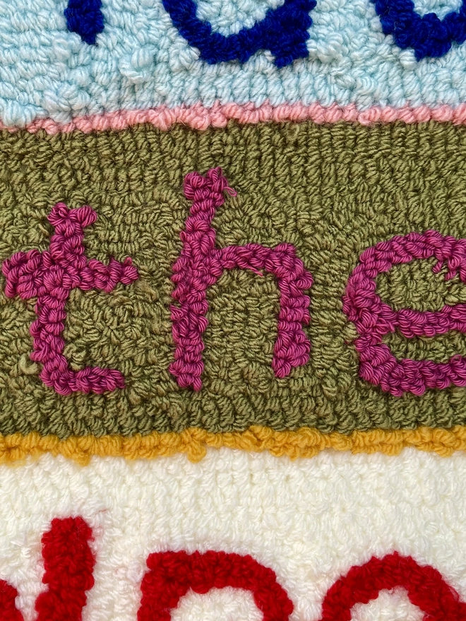 lettering made of woollen tufts in bright colours
