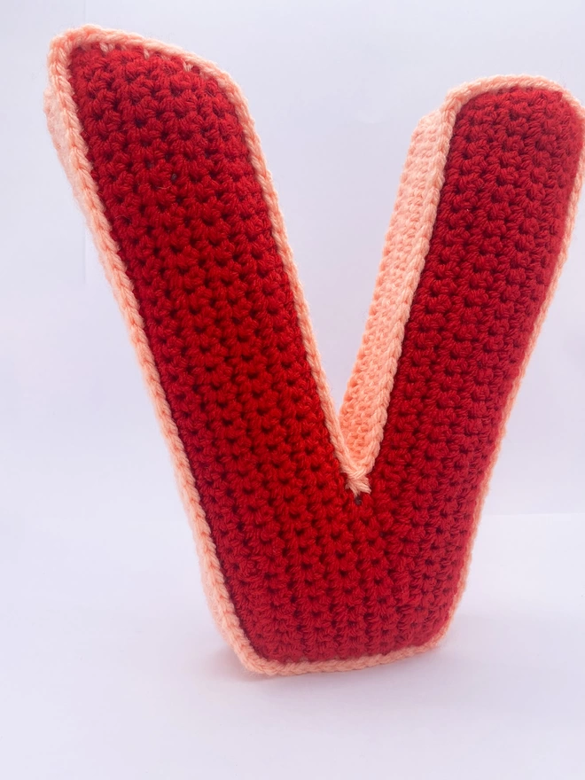 V shaped crochet cushion in red and peachy pink