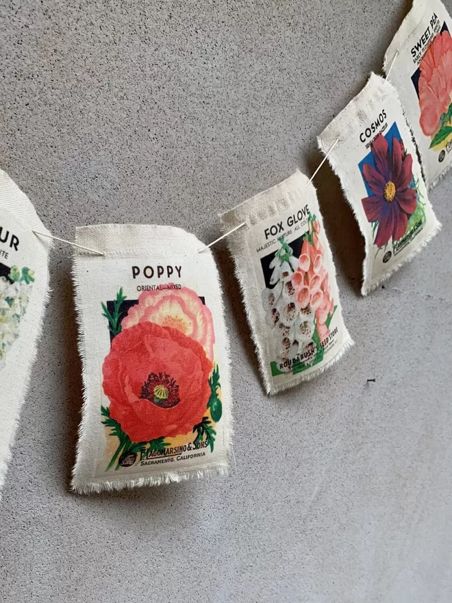 A length of vintage flower seed packet bunting with poppy, foxglove and cosmos