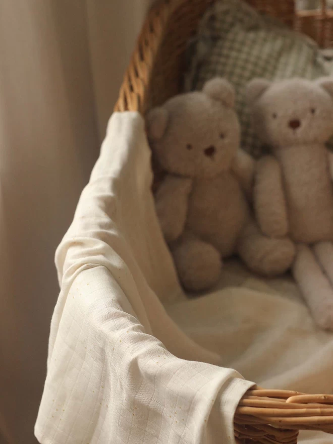 Muslin Swaddle in a changing basket with 2 cute teddies