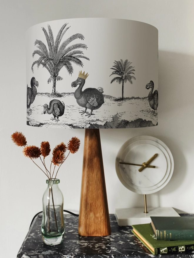 Drum Lampshade featuring Dodos on a wooden base on a shelf with books and ornaments