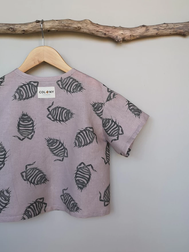 A lightweight soft pink popper down front shirt with charcoal grey woodlouse print and short sleeves.