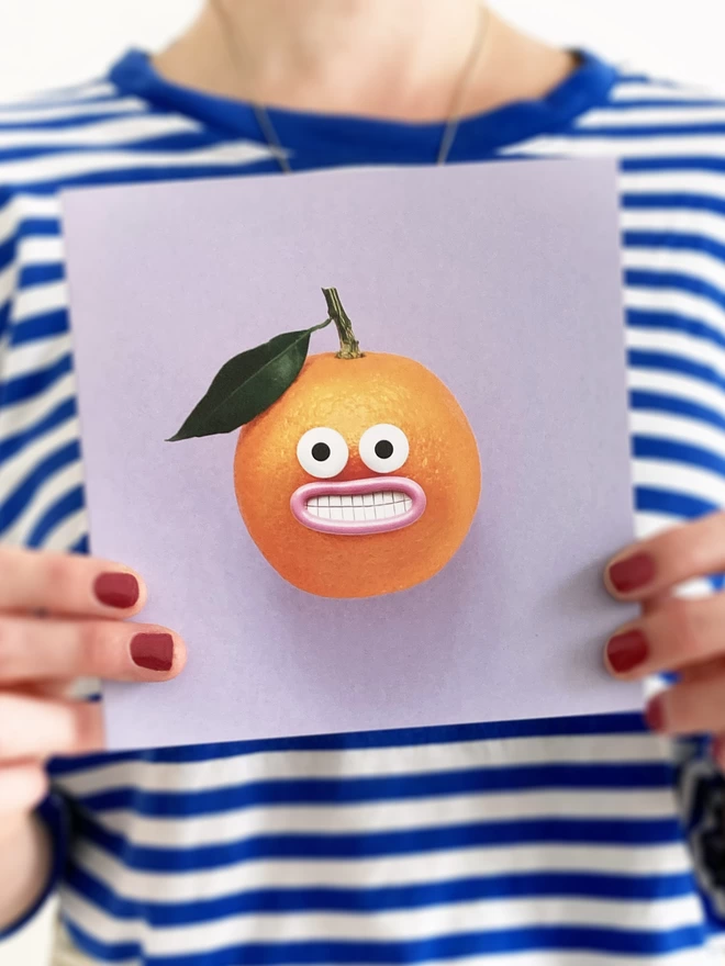 A purple card with a happy orange 