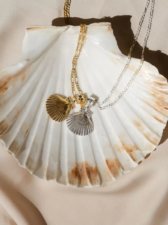 Gold and silver clam shell pendants photographed on white shell by Loft & Daughter