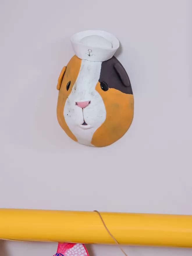 Jerry the guinea pig trophy style head seen from the front on a wall.
