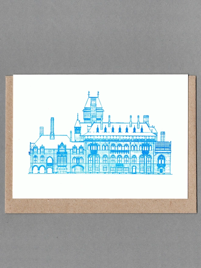 White card with blue illustration of Mount Stuart with a brown envelope behind