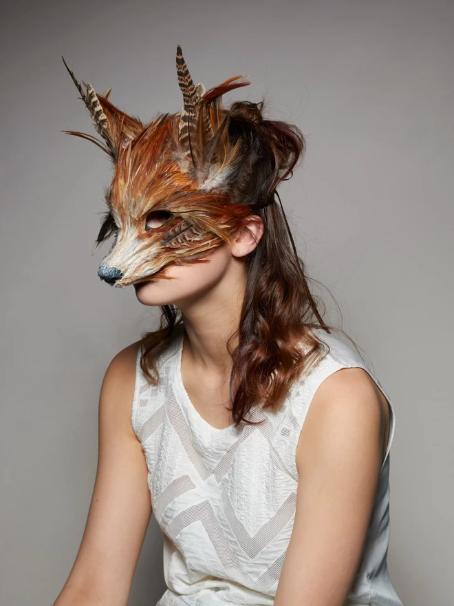 Woman wearing a luxury red fox masquerade mask over her face