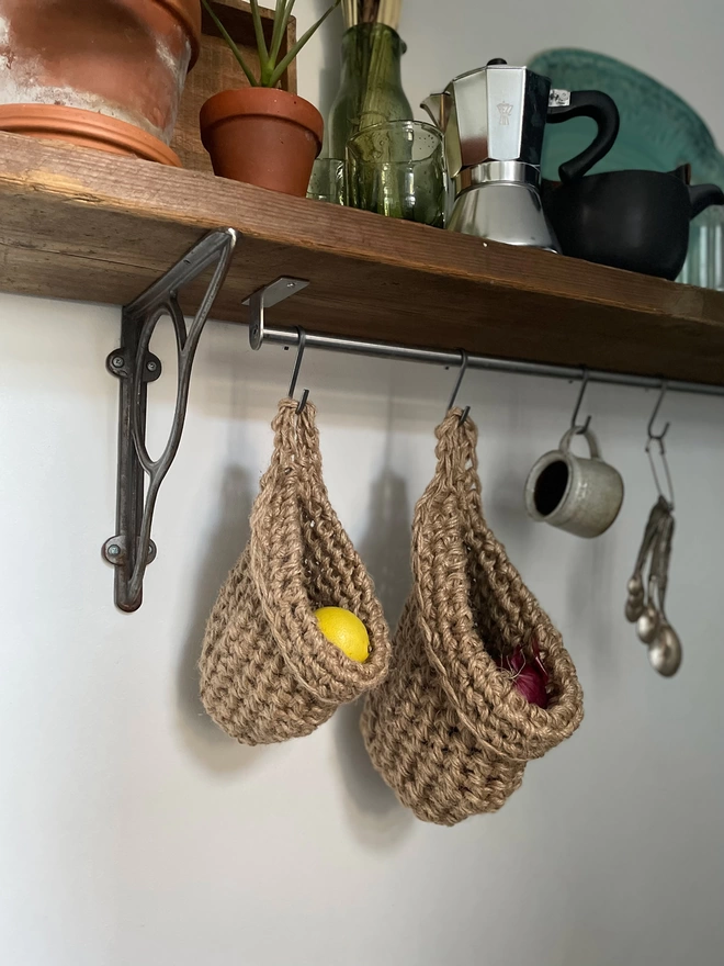 small and large brown jute hanging storage baskets, handmade sustainable crochet decor, rustic natural organic homeware accessories , brown strong jute storage solution, kitchen bathroom bedroom hanging storage bag