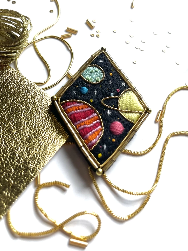 Planets brooch on background with beads