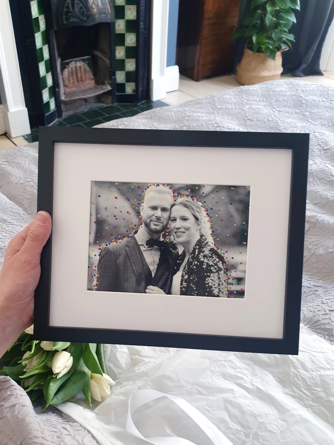 Wedding photo with hand embroidered confetti held in black frame