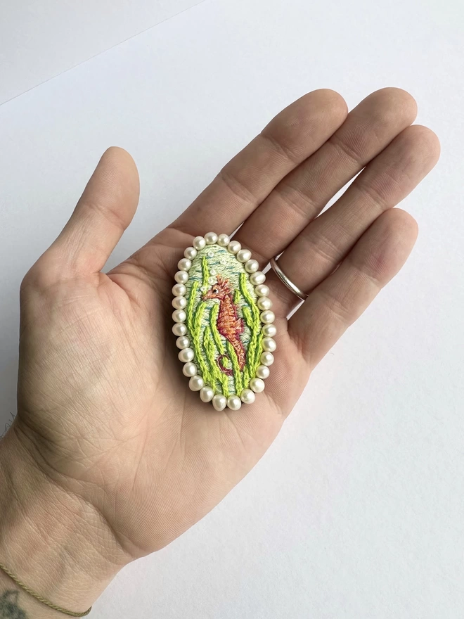 Seahorse brooch sat in the palm of a hand 