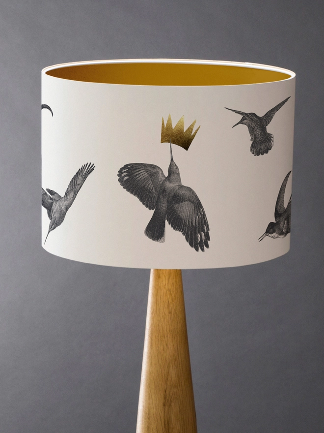 Drum Lampshade featuring hummingbirds with a gold inner on a wooden base 