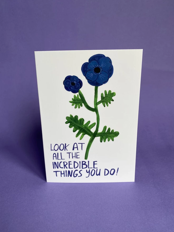 Illustrated blue poppy flower on an A6 greeting card that reads - Look at all the incredible things you do!