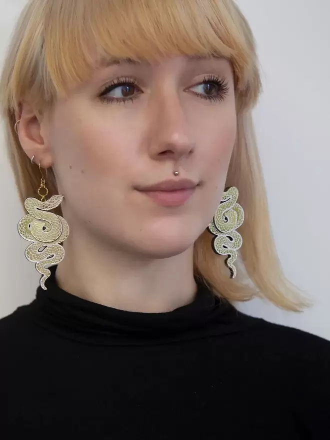 large gold & black ser earrings on blonde model