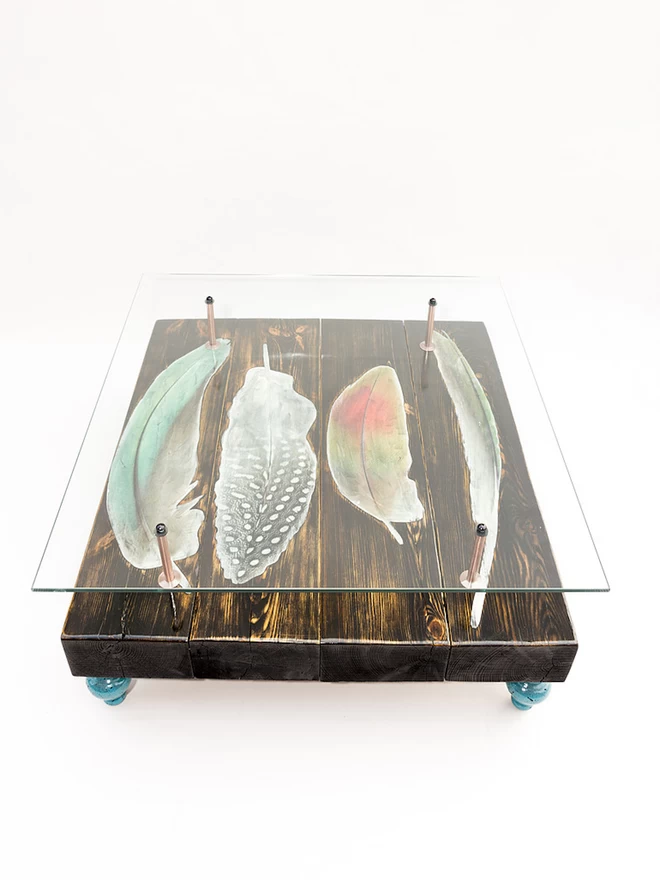 glass top table with bird feathers