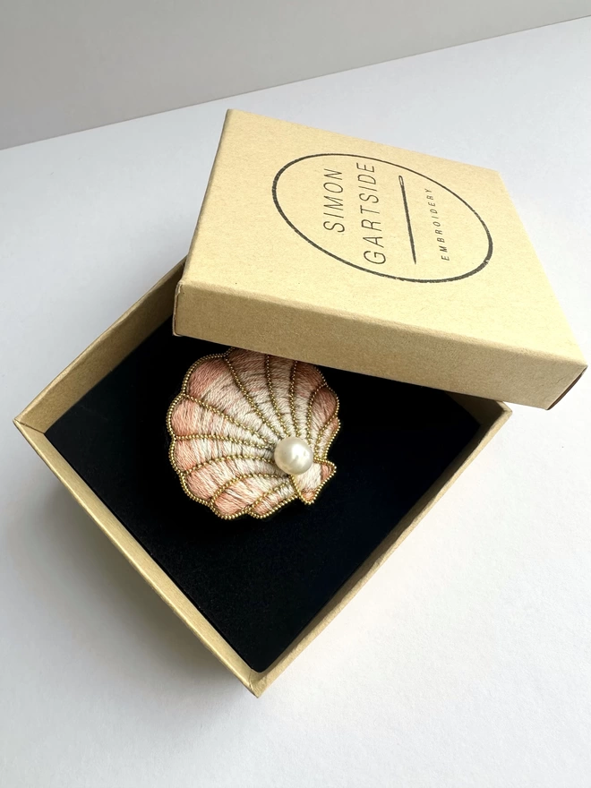 Clam shell brooch with pearl centre sat in a box 