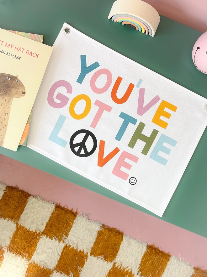 You’ve got the love wall banner with bright coloured lettering on a green table