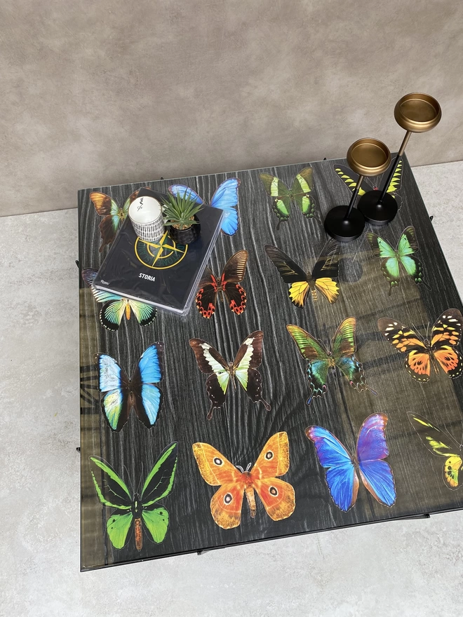 colourful butterflys on a wood grain image in a glass top