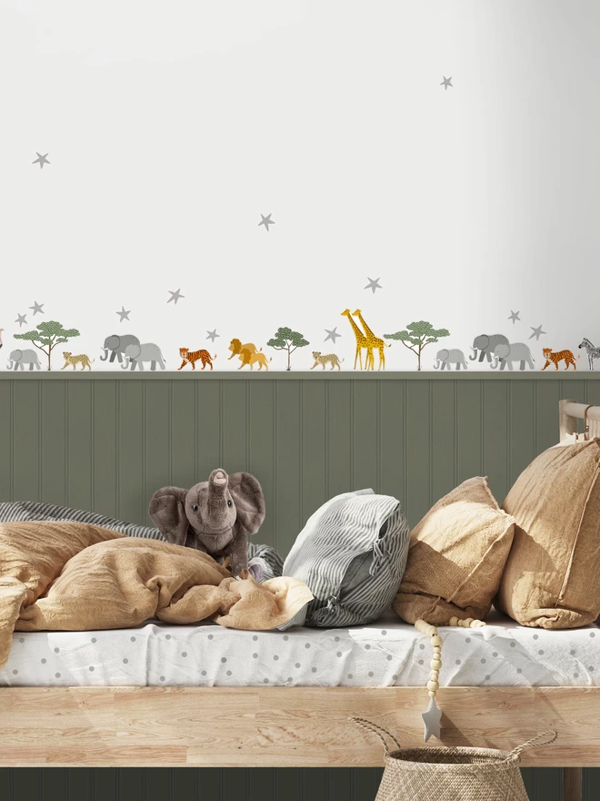 Sarafi animal stickers above green painted wall panelling in kids bedroom