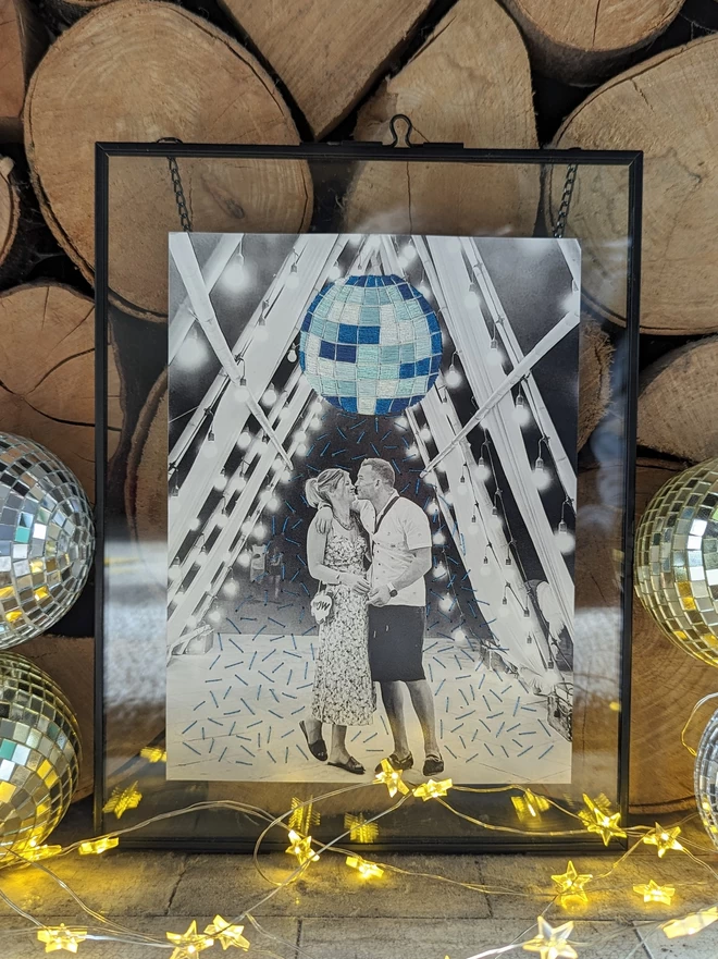 Framed photo of couple with an embroidered disco ball above 