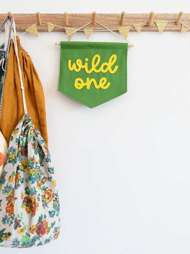 banner with wild one sewn on in cursive font.