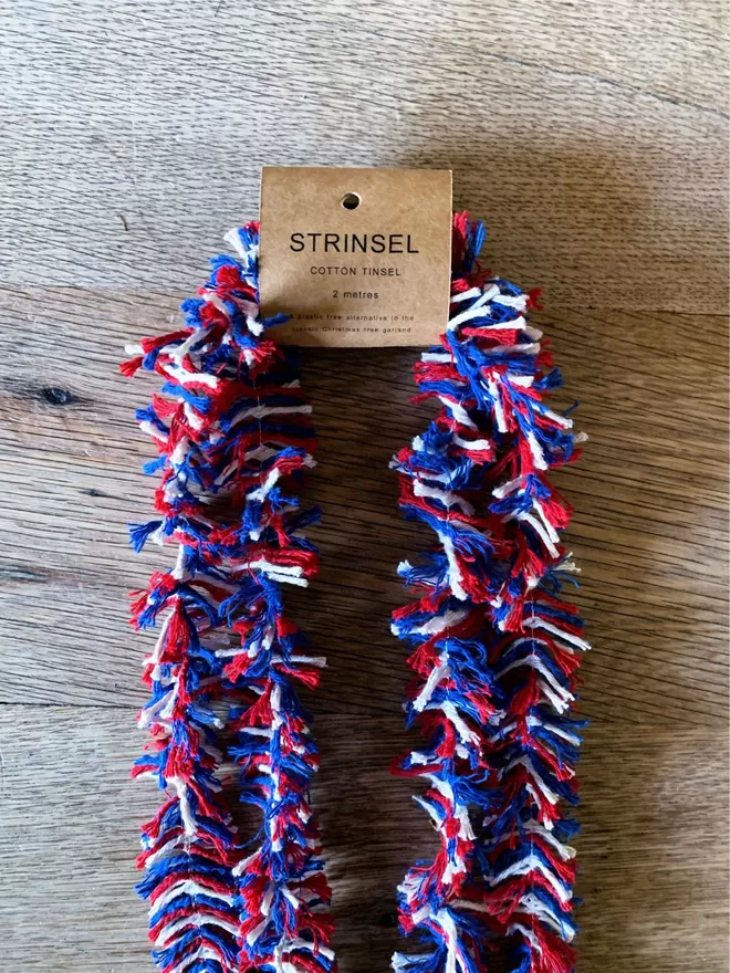 Right Royal Strinsel. Red white and blue string tinsel with label on an oak table