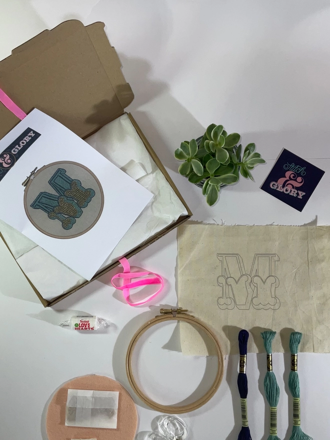 The contents of an embroidery kit laid out on a white surface