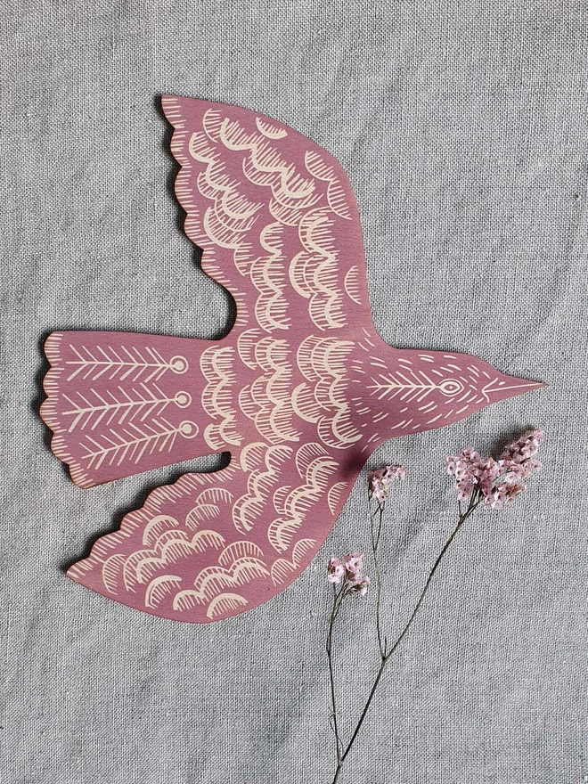 Wall mounted wooden hand printed bird decoration in  rose pink.