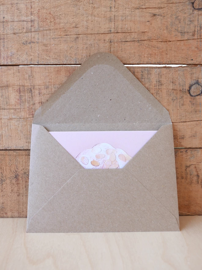 The Almond Croissant Card tucked inside its brown envelope with some card visible