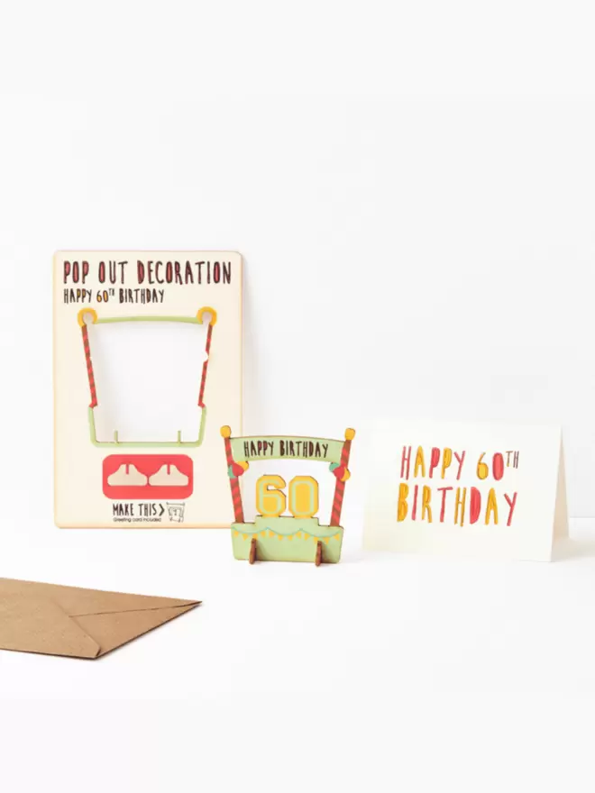 Sixtieth birthday decoration and happy sixtieth birthday card and brown kraft envelope on a white background