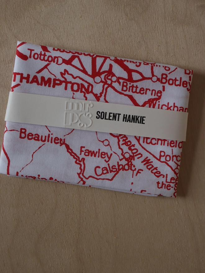 A folded Mr.PS Solent map hankie printed in red