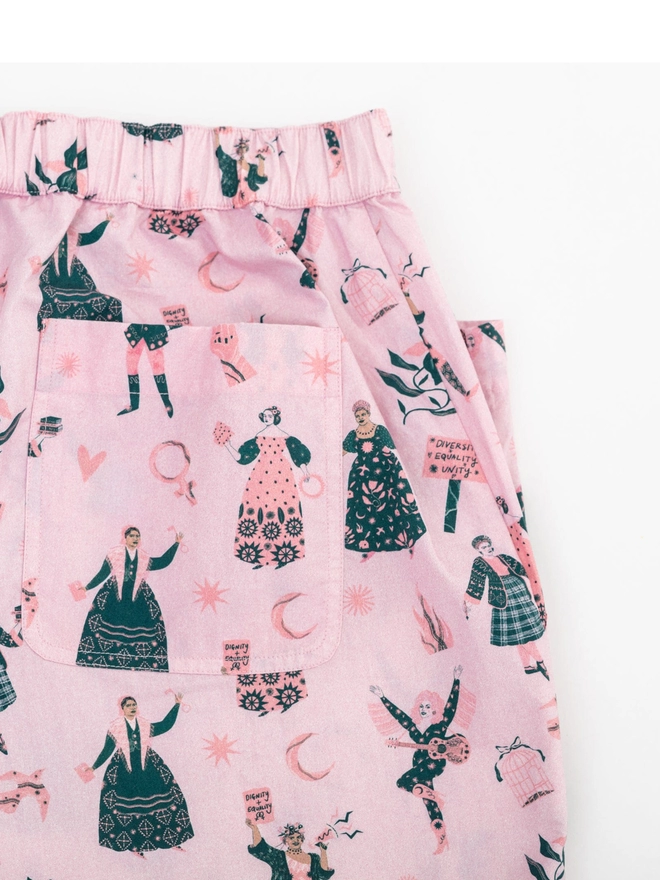 A flat image of Black & beech feminist pyjama bottoms, focus here on the pocket 