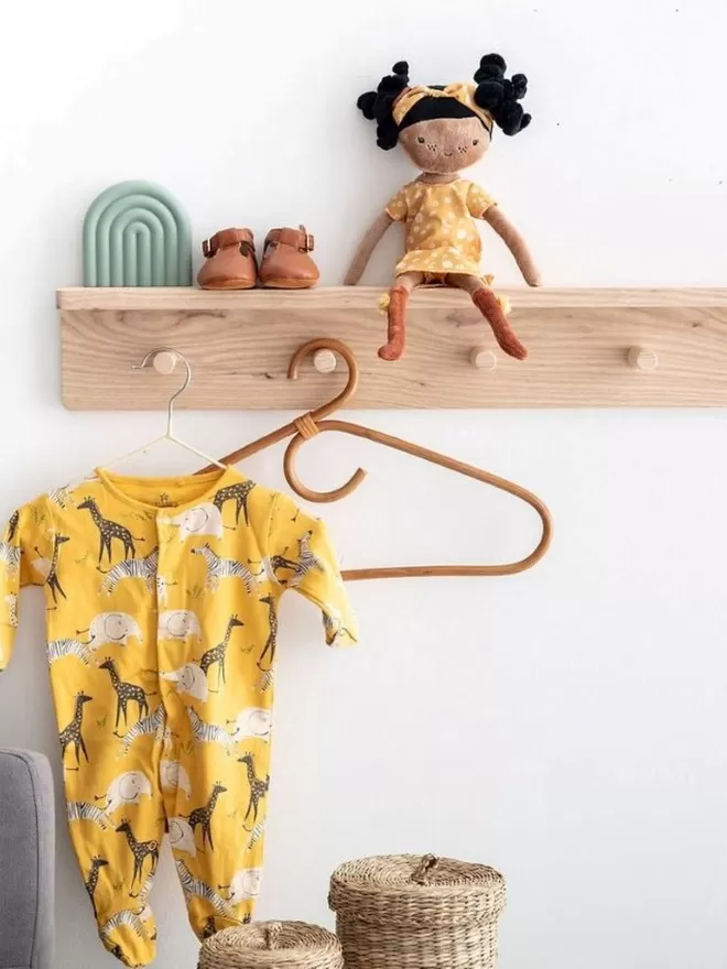 A solid wood pegrail shelf  with children's decor upon it