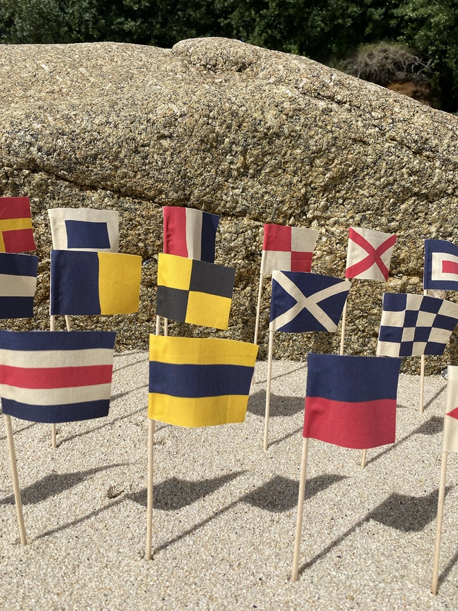 Some nautical signal code sandcastle flags flying n the beach