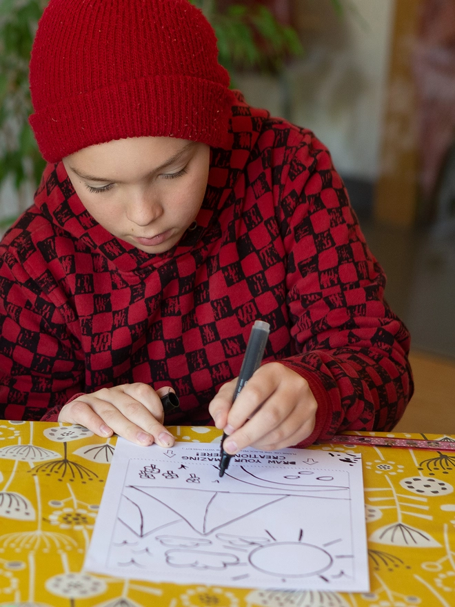 Boy drawing is own design for his t-shirt