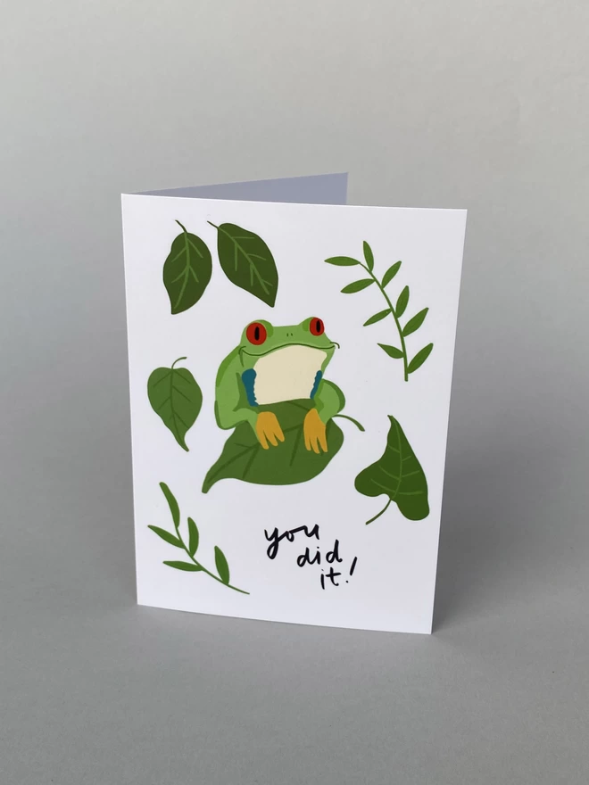 A illustrated Tree Frog on a leaf with other leaves that reads - You Did It!