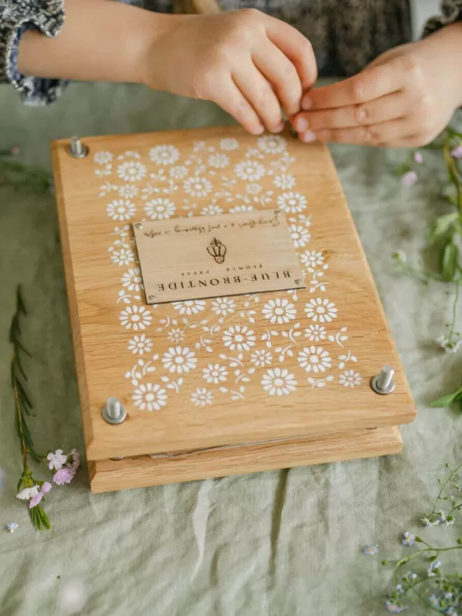 Wooden Flower Press - Delicate Daisy child using the flower press