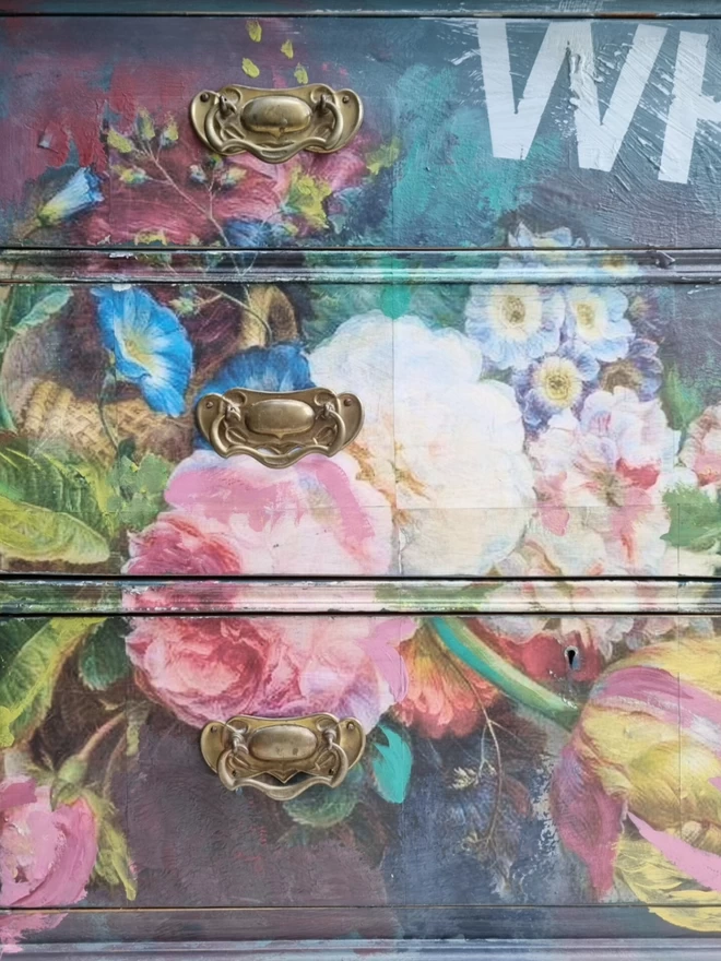Painted vintage table in dark and light blue with a large, statement decoupage floral design and the wording ‘keep being whimsical’ across the front. 