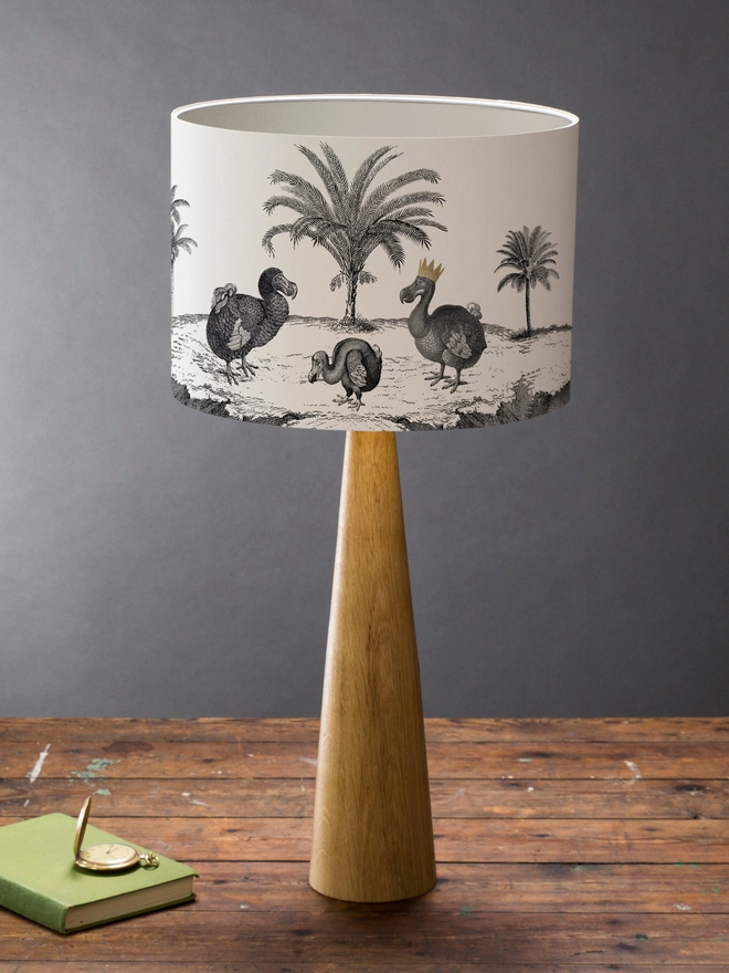 Drum Lampshade featuring Dodos on a wooden base on a shelf with books and ornaments
