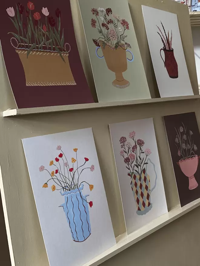 prints of icelandic poppies, Yarrow, fritillaria, Queen Annes lace and Tulips on shelving. 