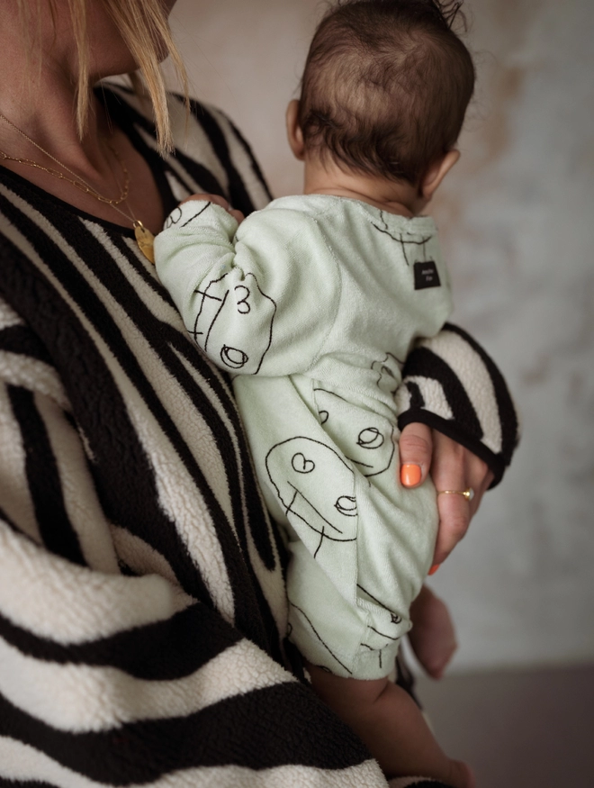 Another Fox Olive Freds Face Terry Towel Romper seen on a baby from the side.