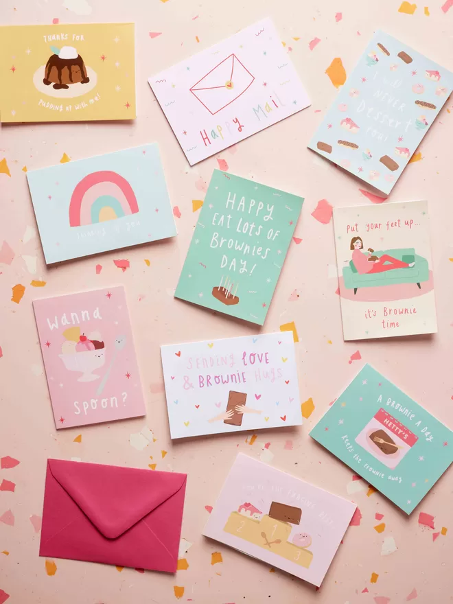 Colourful card designs and envelop against a terrazzo background
