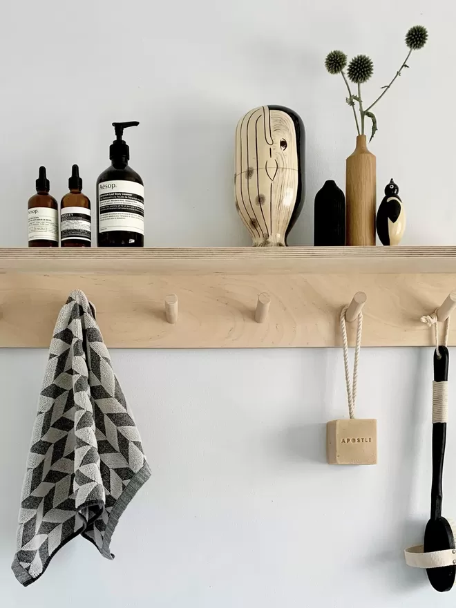rack in the bathroom with bath brush, soaps and towel