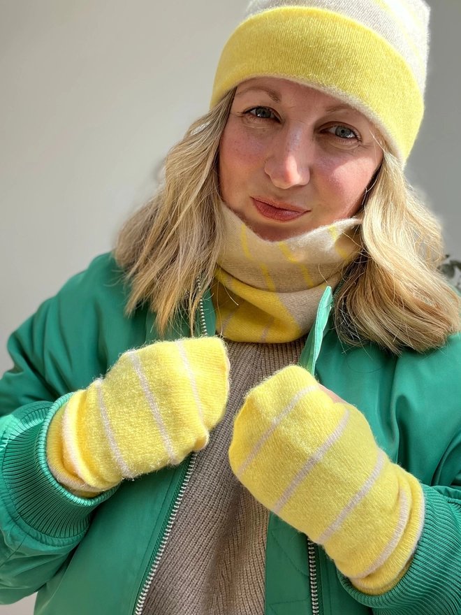 Yellow knitted wristwarmers worn with matching snood and beanie hat
