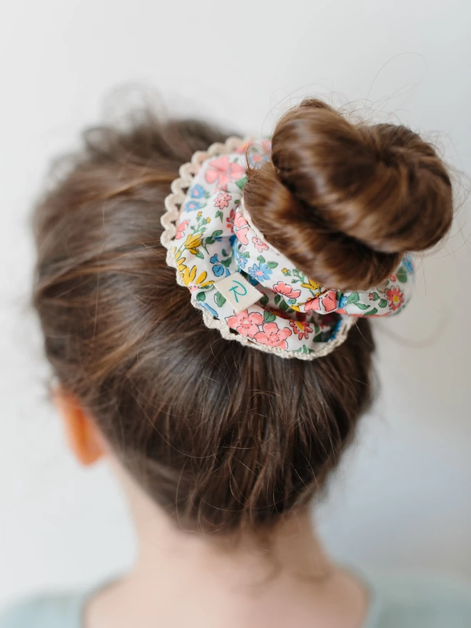 Girl with long brown hair with a liberty lace edge hair tie