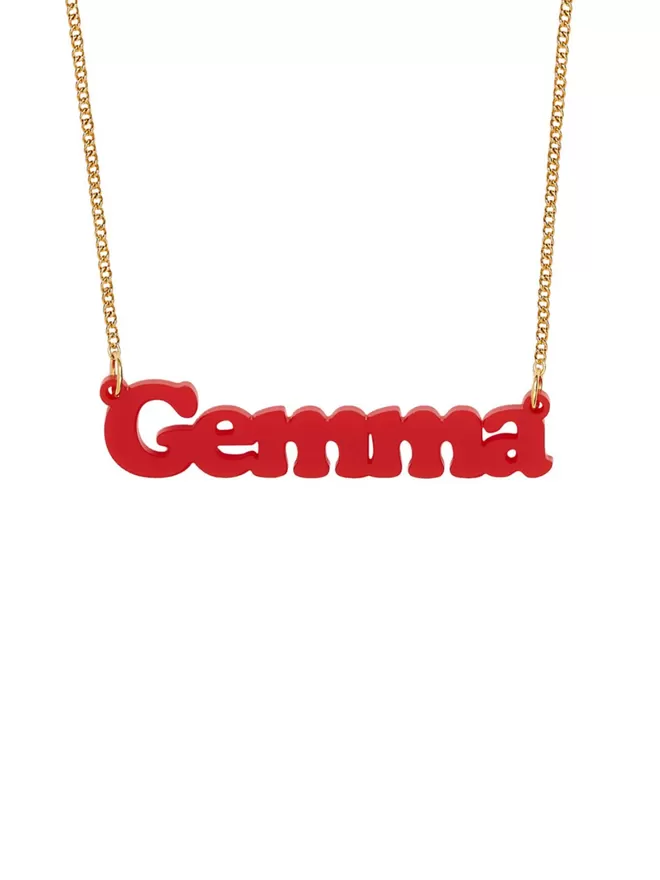 Personalised Name Neckace from Tatty Devine. The Necklace is the word Gemma laser cut from Recycled Red Acrylic on a gold-plated chain.