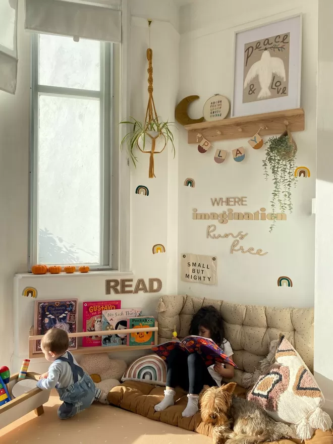 A kids play corner. A beautiful solid wood pegrail shelf is styled up with kid's prints, plants and wall decor.